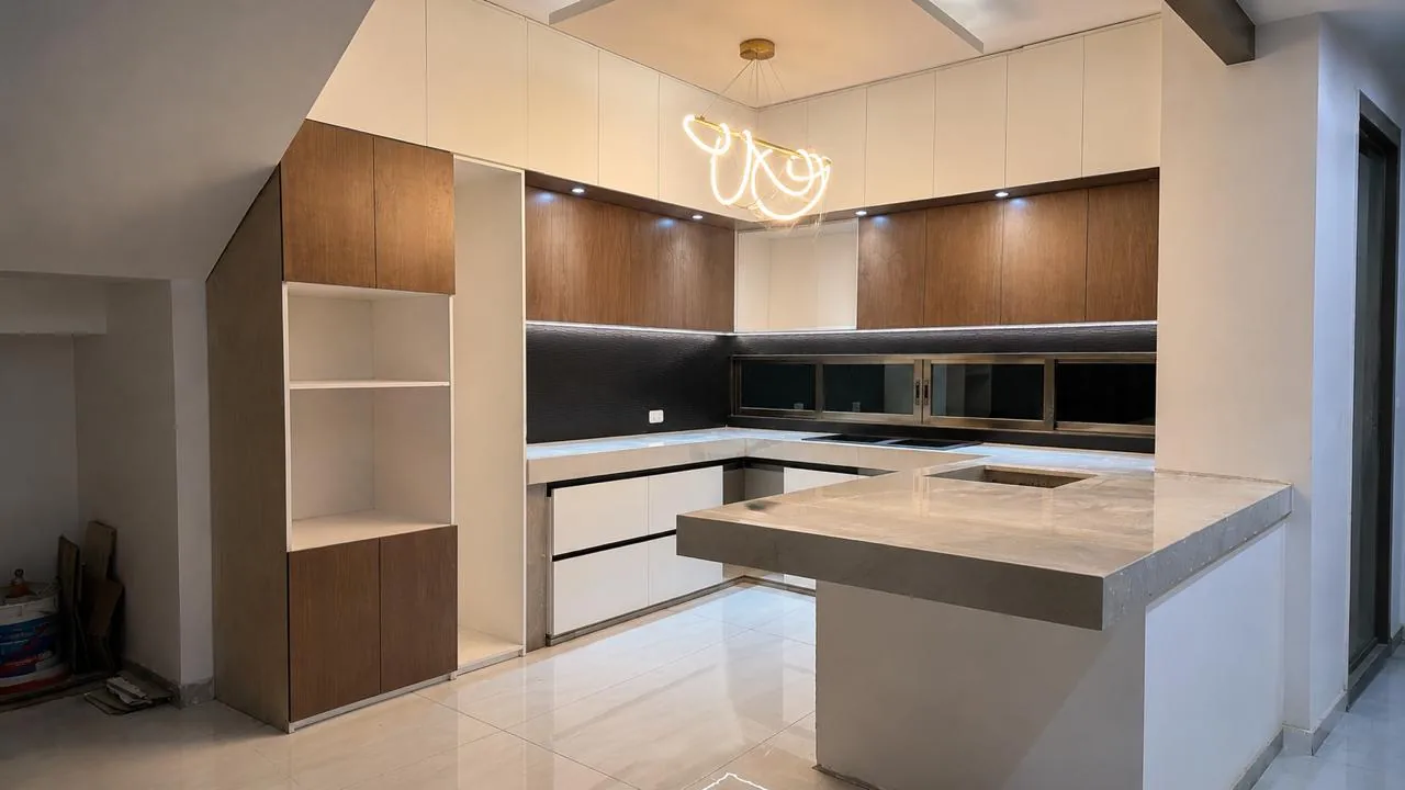 Cocina off white terminada desde el mismo ángulo, con gabinetes de nogal, cubiertas de cuarzo y backsplash negro texturizado